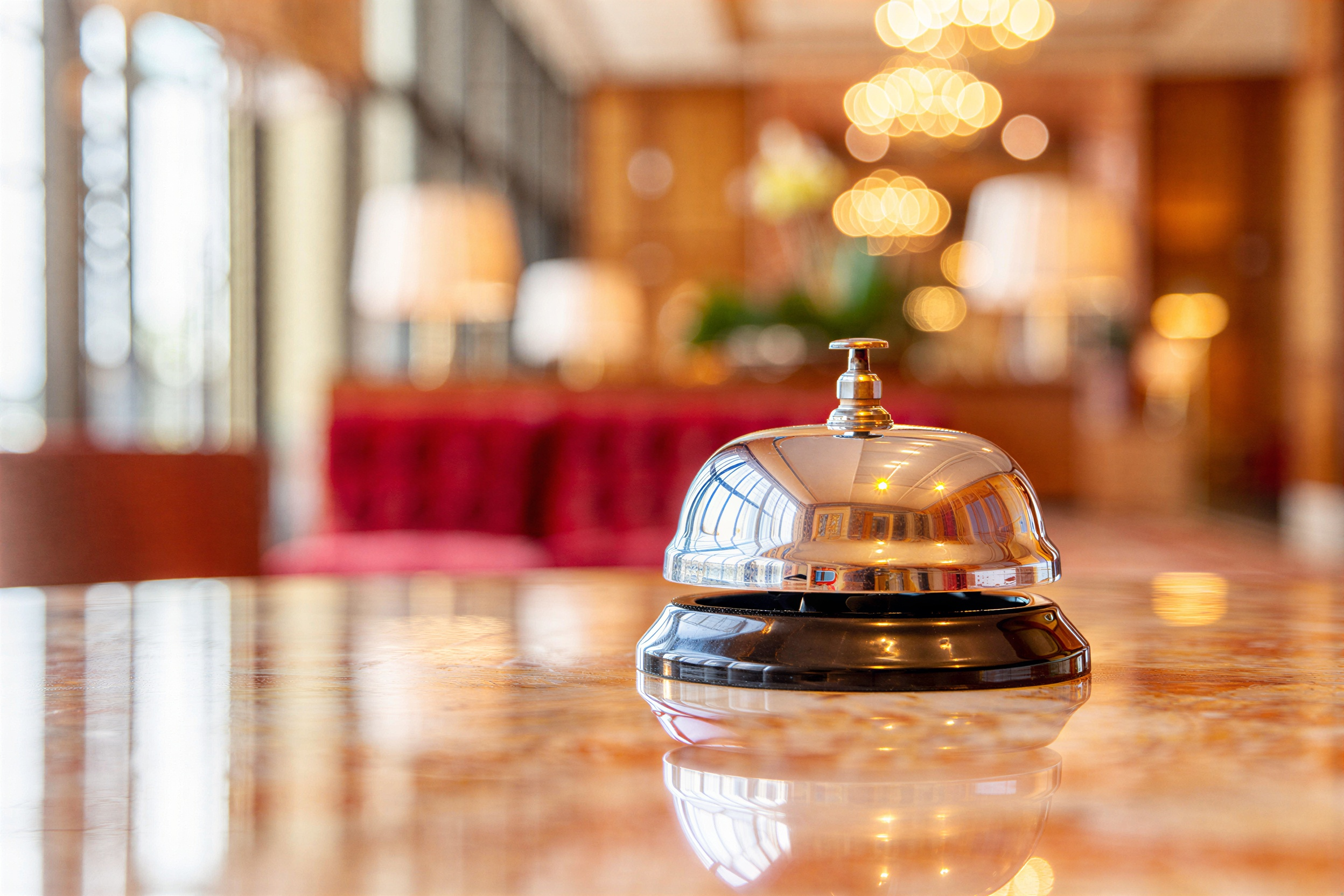 Detail of a hotel reception desk bell in a brightly lit room. 