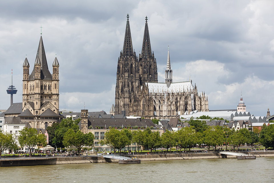 Cologne Cathedral and the Hohenzollern Bridge reflected in the Rhine at dusk