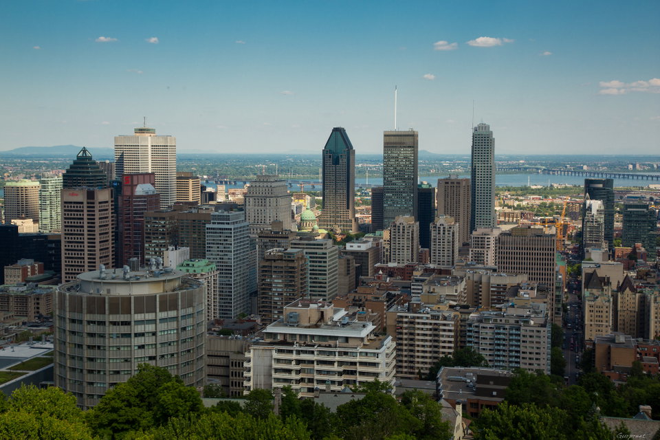 Montreal skyline at dusk with the illuminated dome of Saint Joseph's Oratory and the downtown skyscrapers reflected in the St. Lawrence River