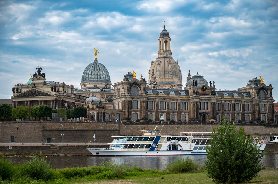 Dresden's Baroque skyline reflected in the River Elbe at dusk, with the Frauenkirche dome rising above the rooftops