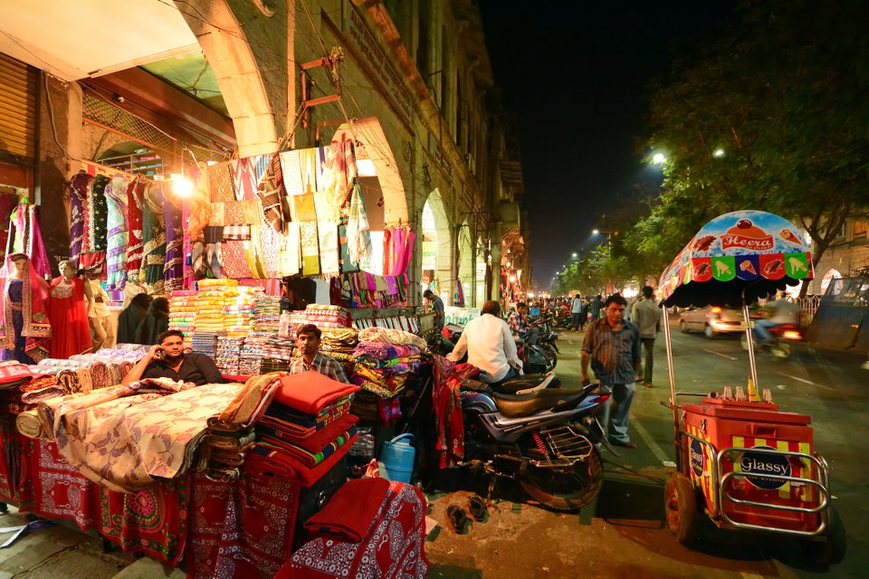 The illuminated Charminar monument at dusk with bustling bazaars in the foreground, Hyderabad
