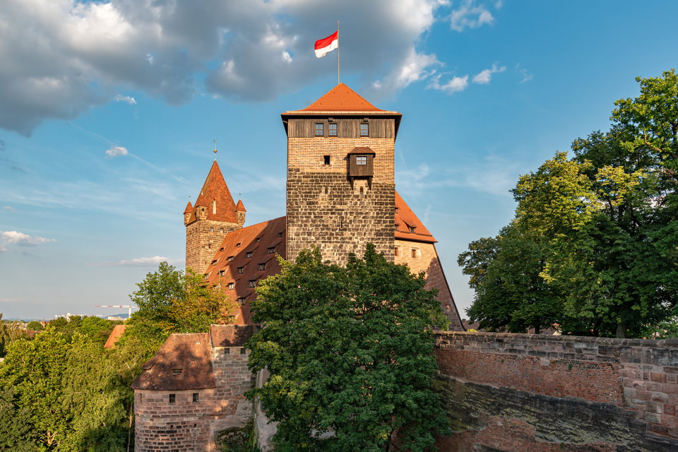 Nuremberg's medieval Imperial Castle rising above the red-roofed Altstadt at dusk