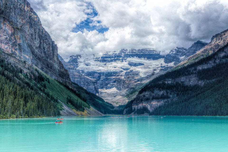 Turquoise waters of Lake Louise framed by snow-capped Rocky Mountain peaks and a glacier, Banff National Park, Alberta