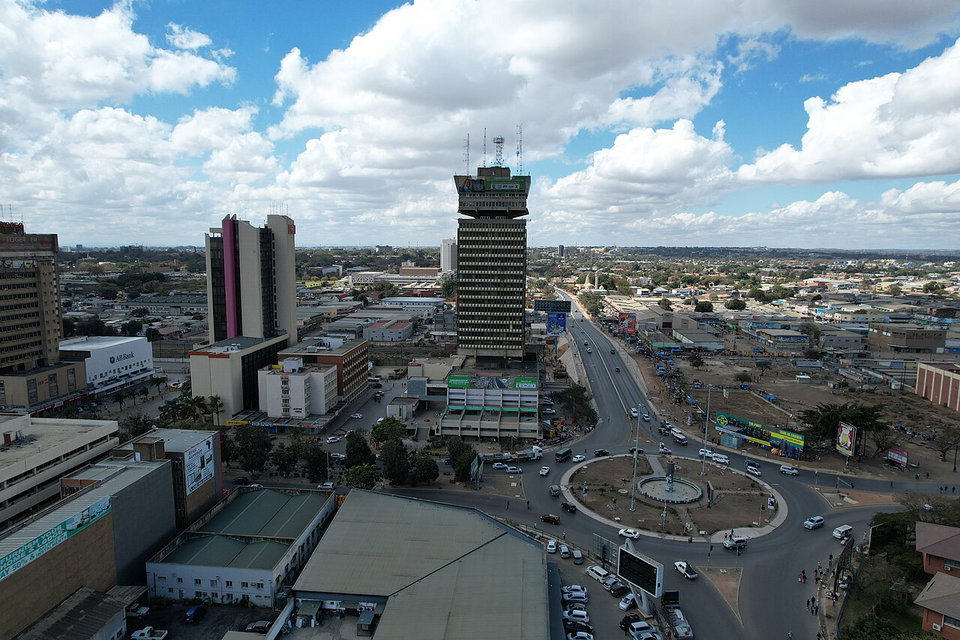 Lusaka city skyline at dusk with the Cairo Road business district lit up against a purple sky