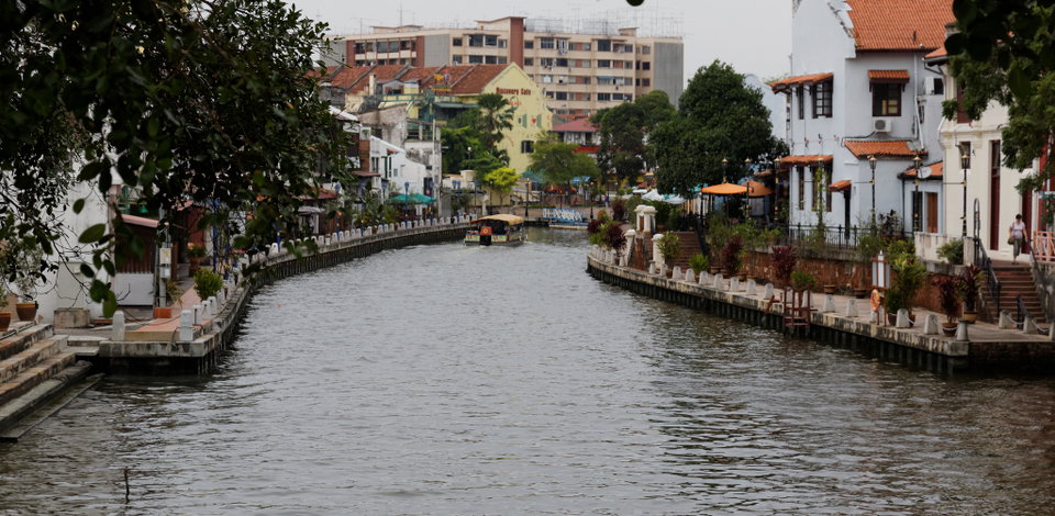 Colourful Jonker Street shophouses lining the Malacca River at dusk