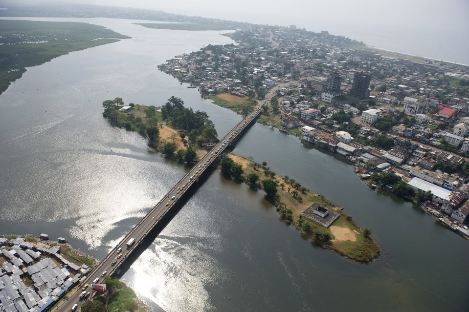 Aerial view of Monrovia's Atlantic coastline with fishing boats and the city skyline at dusk