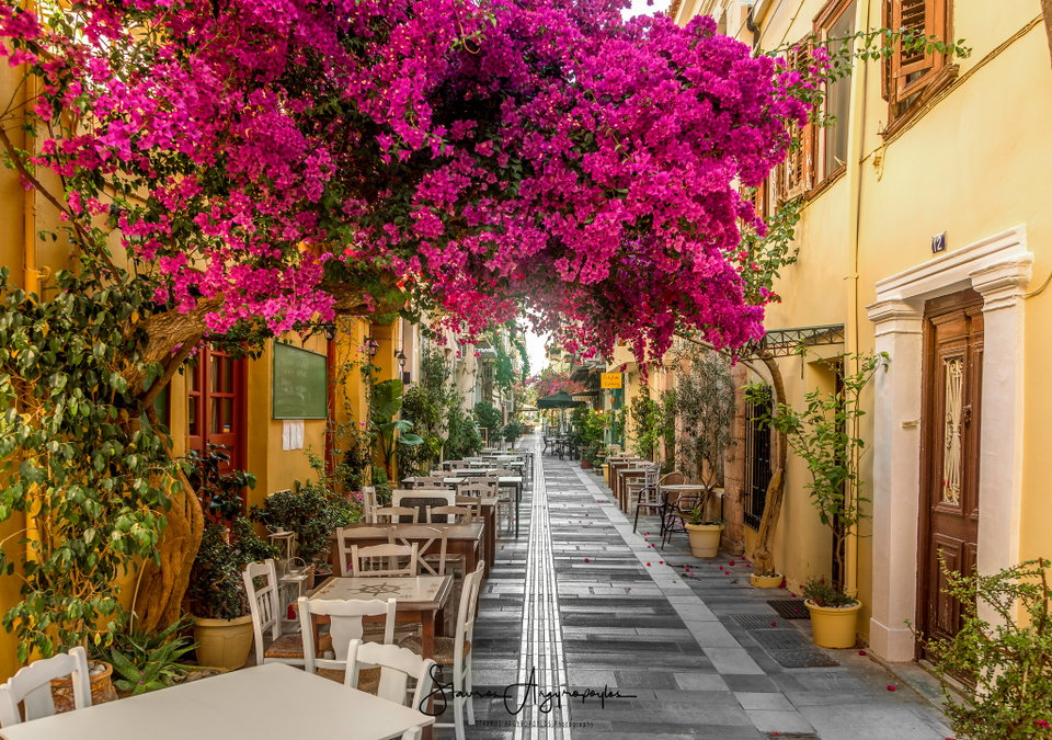 Nafplio old town waterfront with Bourtzi fortress on the water and Palamidi castle rising above the terracotta rooftops