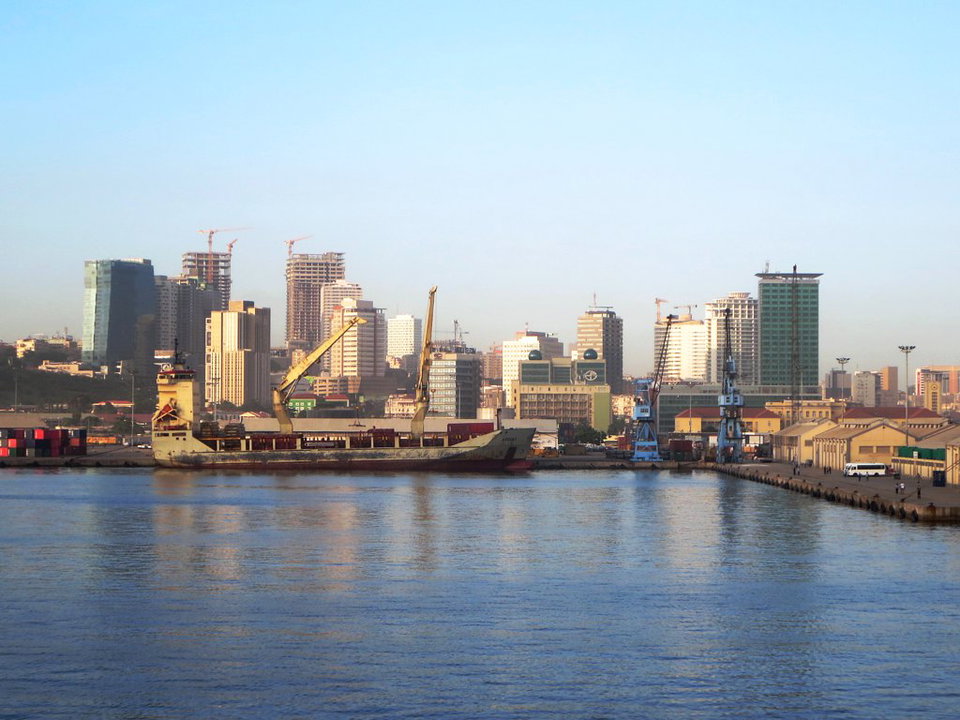 Luanda Bay waterfront at sunset with the Marginal promenade and modern skyline reflected in the Atlantic Ocean