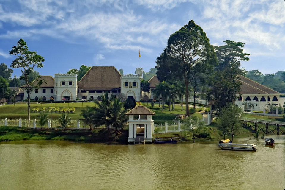 Kuching waterfront at dusk with the Sarawak River and colourful shophouses reflected in the water