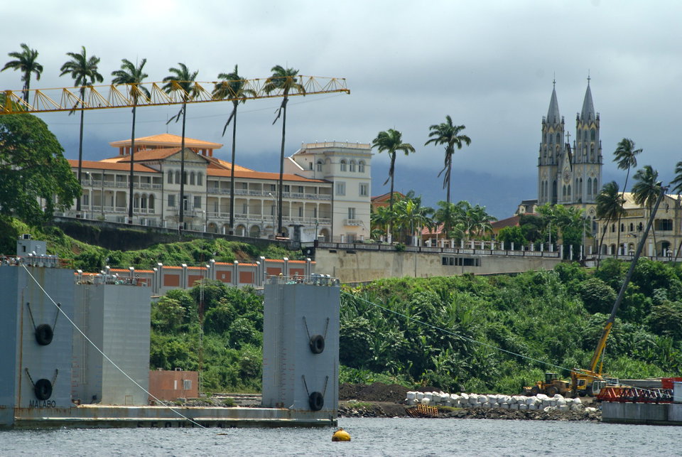 Malabo city waterfront with colonial-era cathedral and lush Bioko Island hills in the background