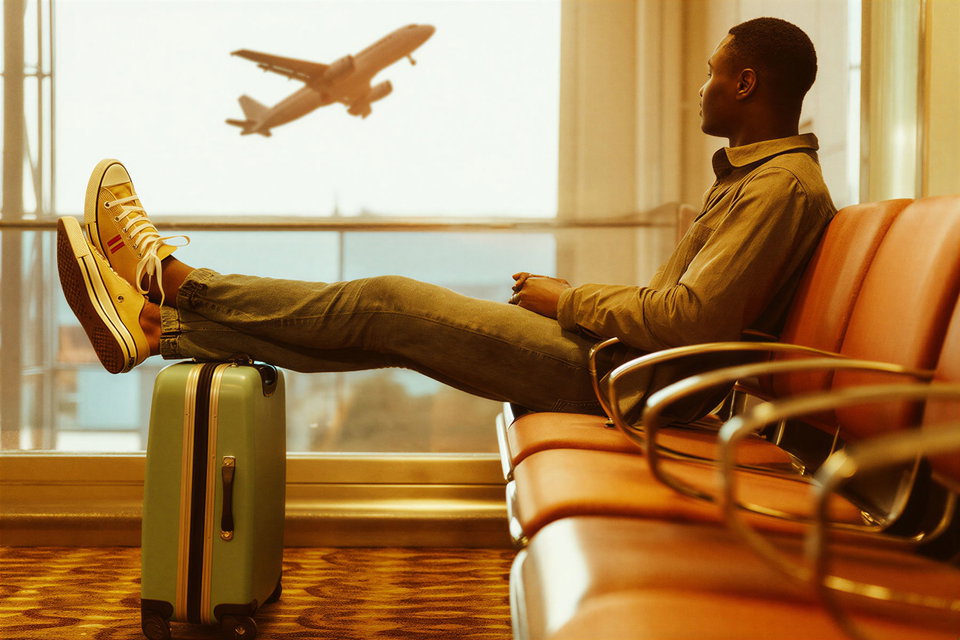 A young man waits for a plane at an airport. 