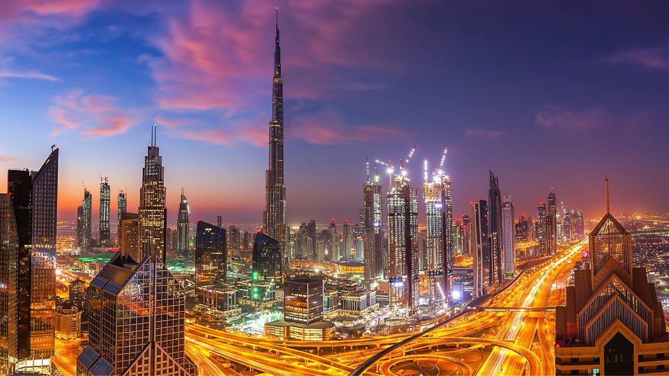Dubai skyline at dusk with the Burj Khalifa towering above the city lights