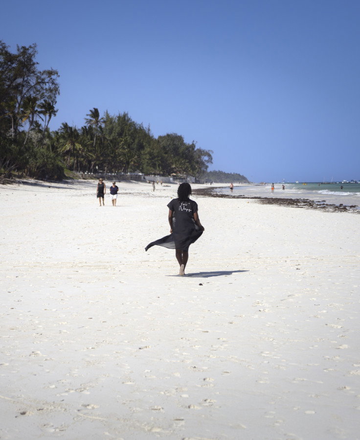 A woman walks on Diani Beach. Photo by Joshua Wanyama.