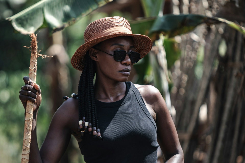A woman in Uganda poses for a photo wearing sunglasses. Photo by Lisa Marie Theck.