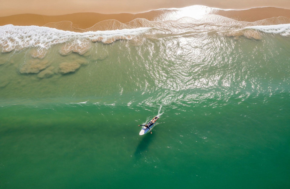 Surfer paddles out to sea